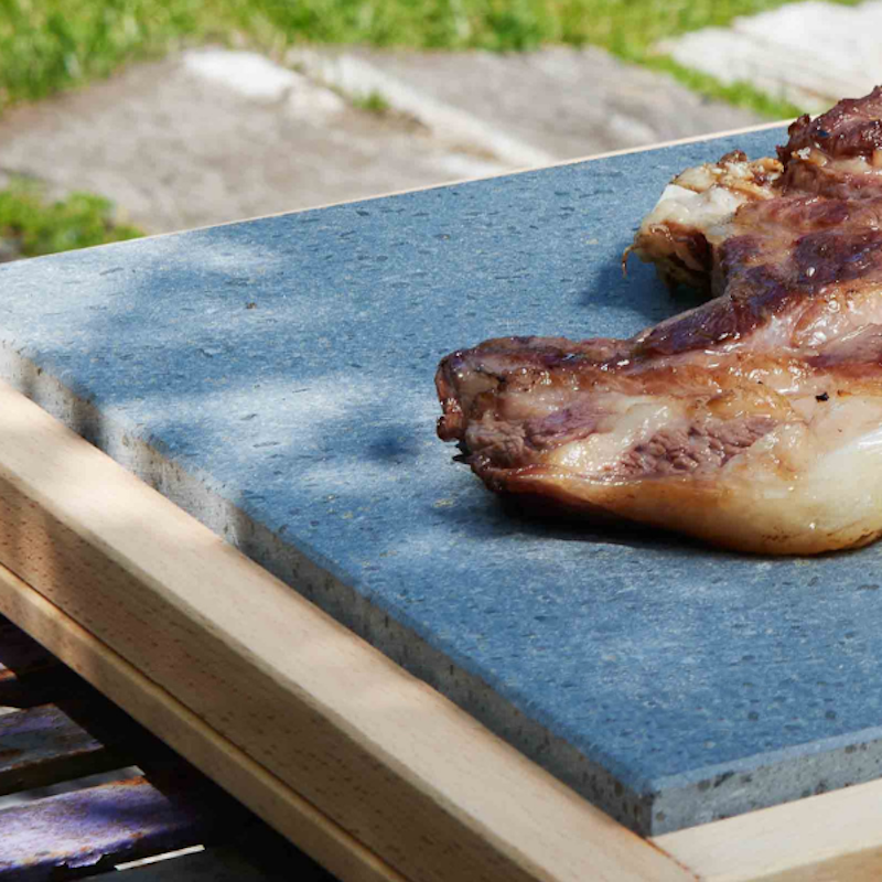 Tabla de cortar de madera con piedra de lava para cocinar.