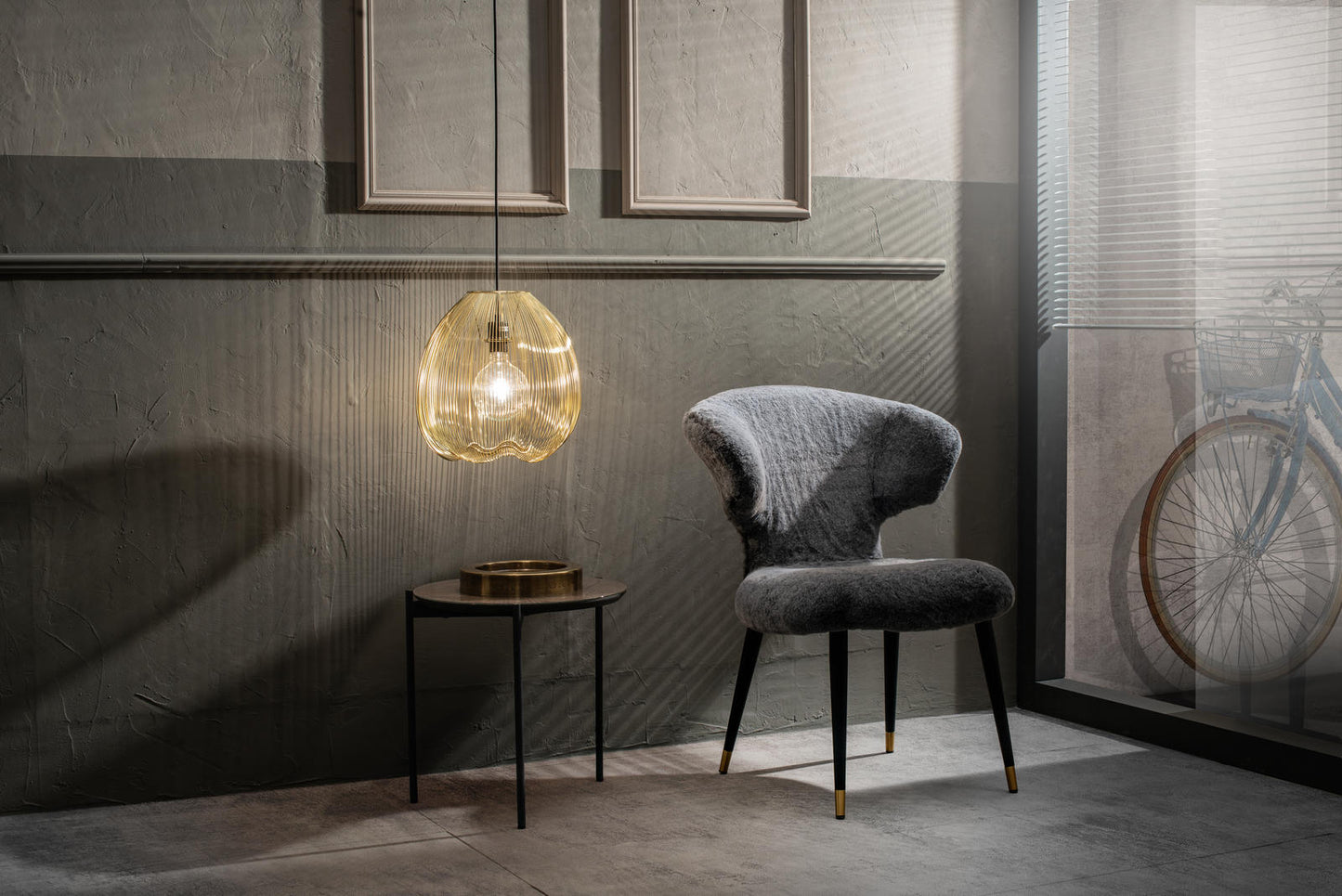 Sillón de pelo sintético gris y patas negro/oro.